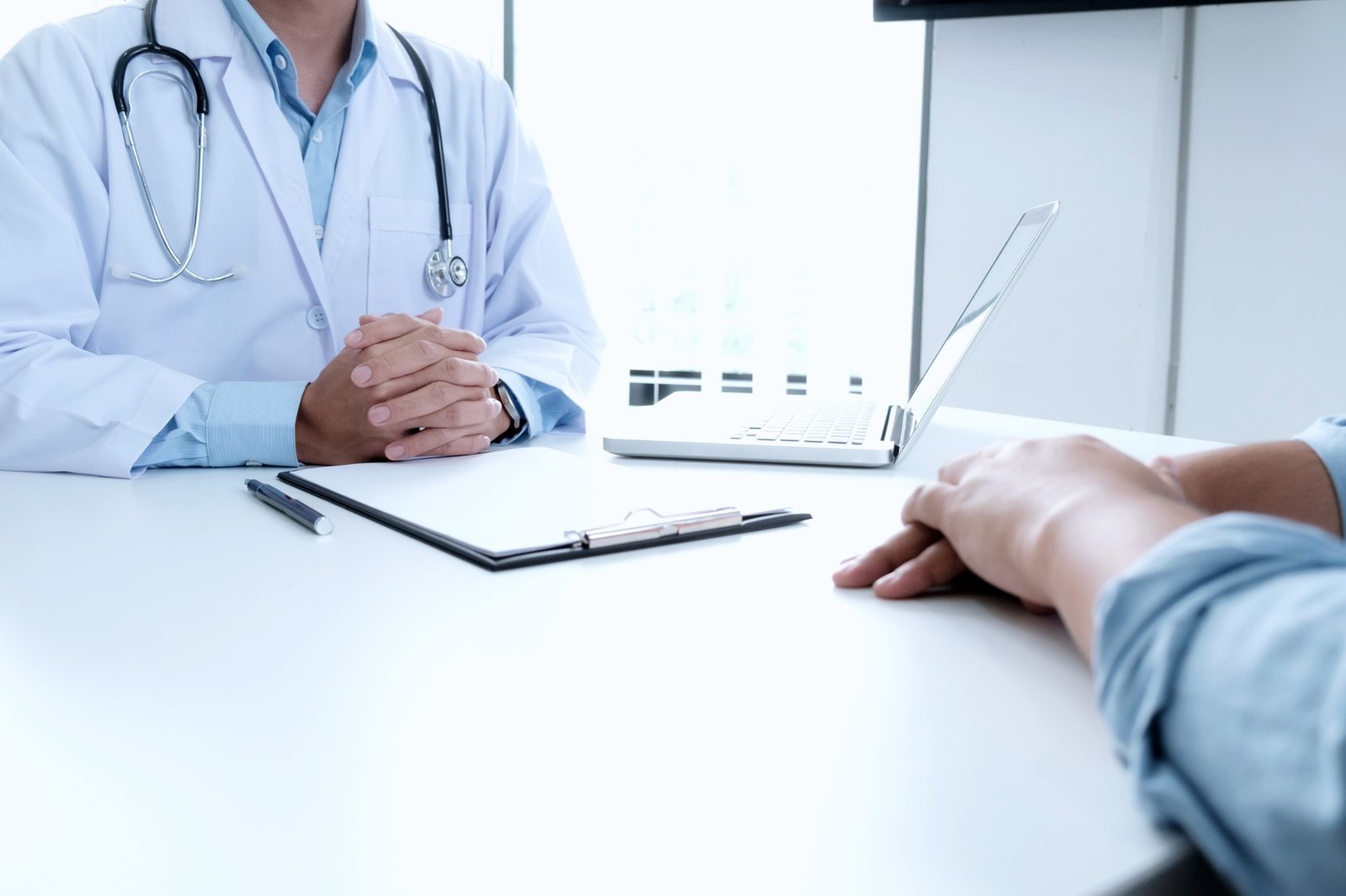 Médico en consulta resolviendo dudas con un paciente