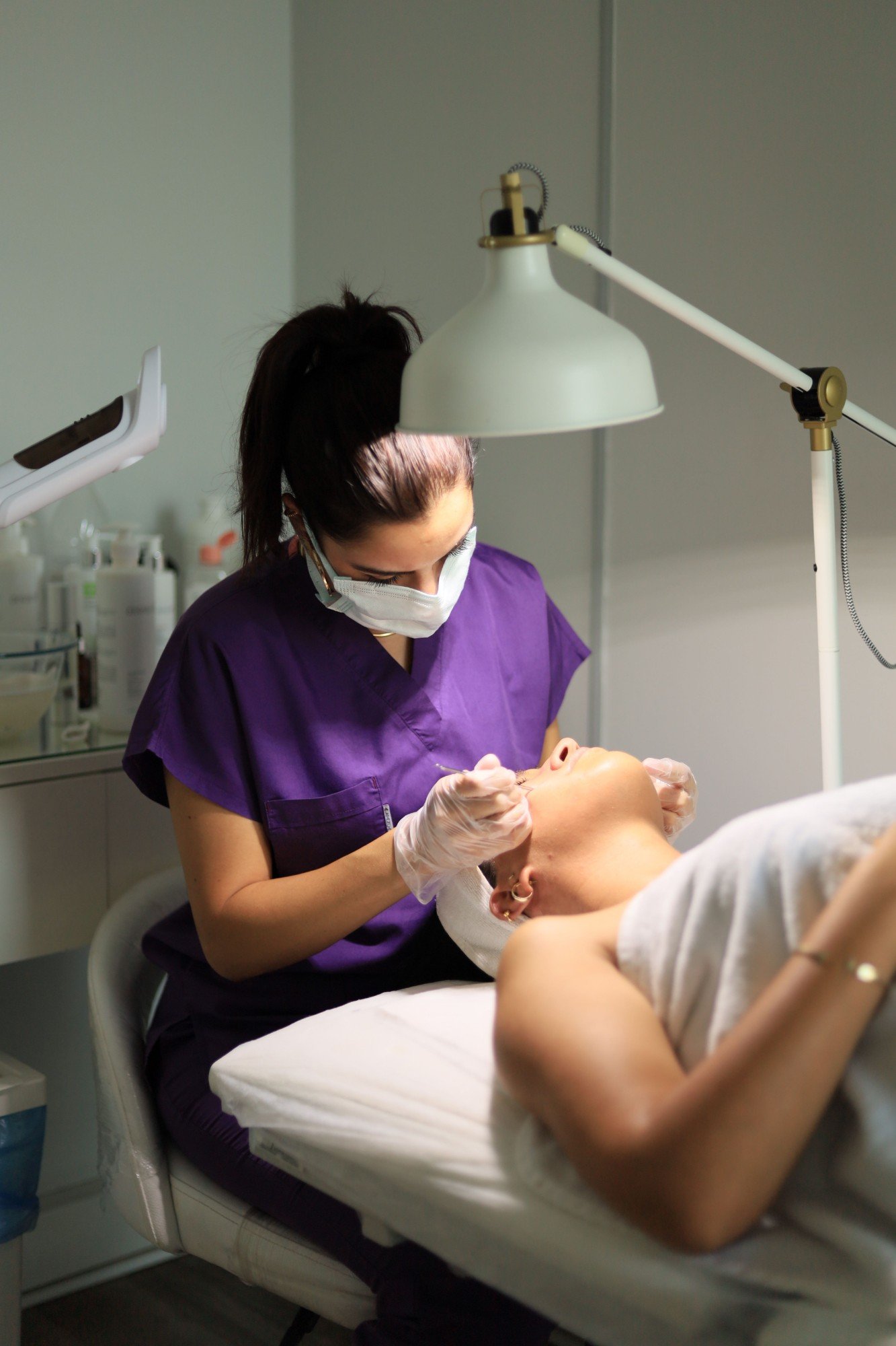 Especialista realizando un procedimiento facial en consultorio